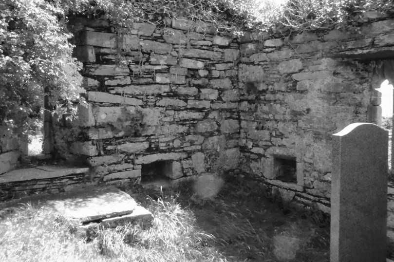 Inside the church, showing the ogival windows, the altar, piscina or stoup, and a small recessed cupboard